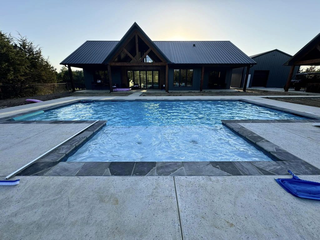 Brashear (BP-2001) Barndominium Floor Plan — 3 Bed, 2.5 Bath, 2,567 Sq Ft 6 Swimming pool alongside a completed Brashear BP-2001 barndominium — covered patio and outdoor living area